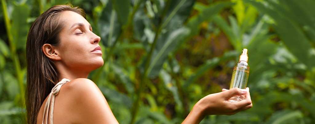 Woman holding a Spa Ceylon mist among tropical leaves